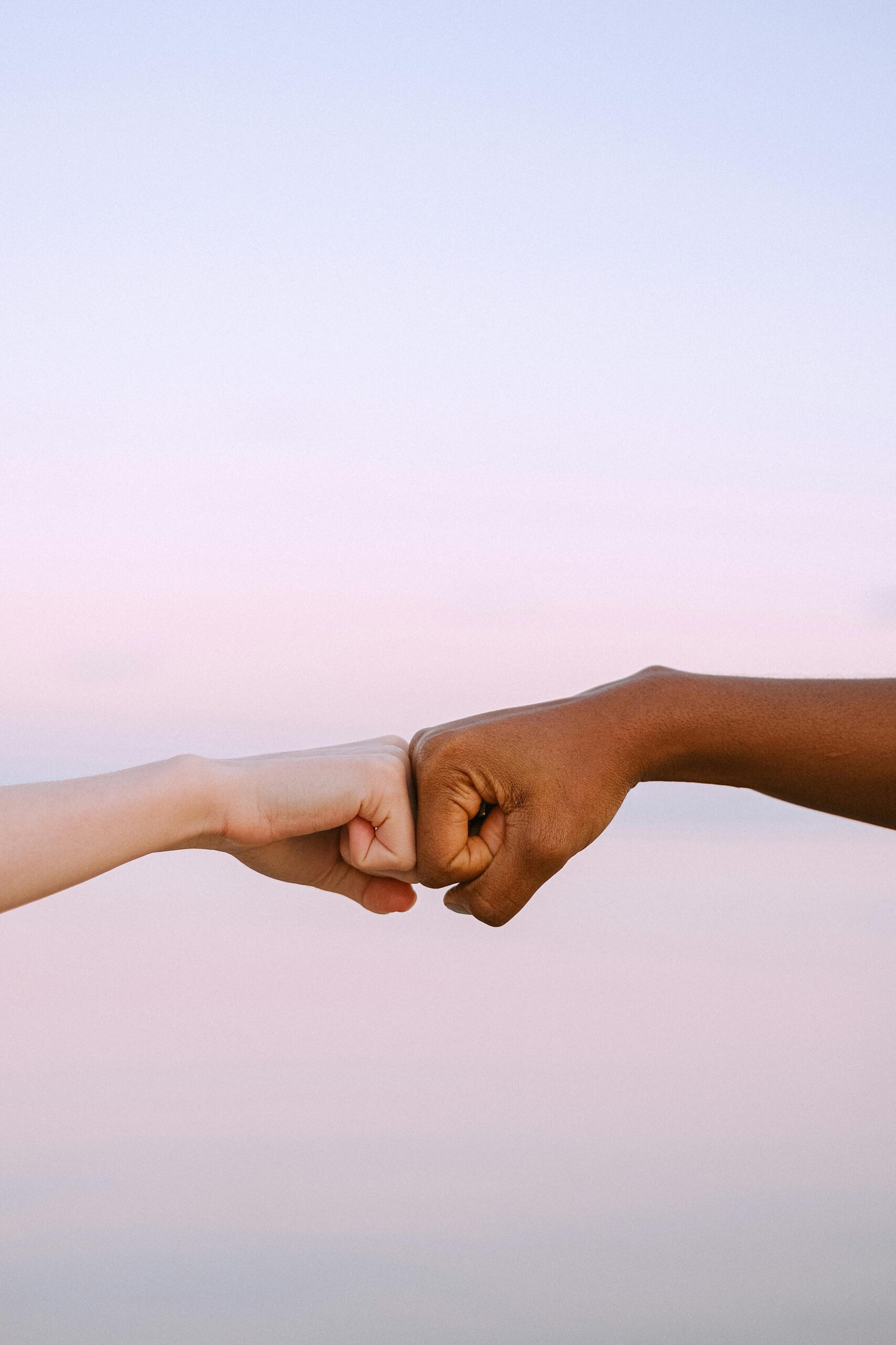 Close-up of a diverse handshake symbolizing unity and cooperation on a neutral background.